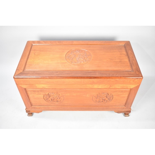 551 - An Oriental Camphor Wood Chest with Hinged Lid Having Carved Dragon Details, 101cms Wide