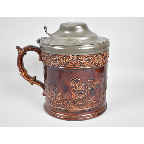 66 - A 19th Century Treacle Glazed Pewter Lidded Tankard, Body Decorated in Relief with The Winged Lion o... 