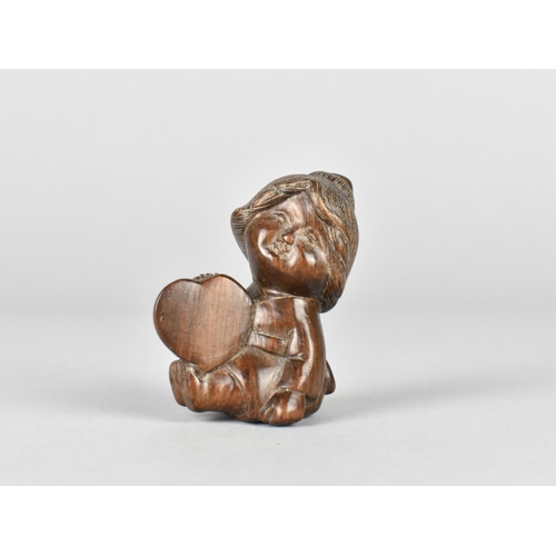 31 - A Carved Rosewood Netsuke, Seated Young Girl Holding Heart, Signed to Base, 5.25cms High