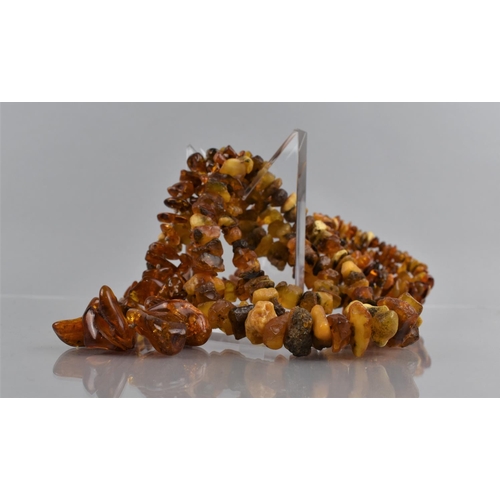 462 - Two Long Strings of Raw Amber together with a Raw Amber Chip Three Row Bracelet, Largest Chip 34mm L... 