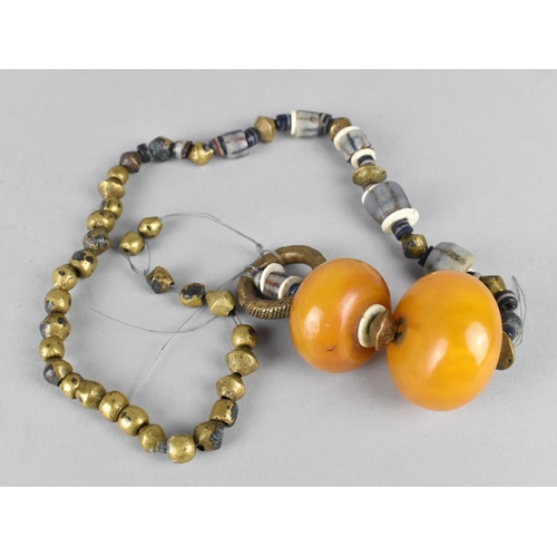 463 - A Far Eastern Type Beaded Necklace Housing Two Large Amber Coloured Beads, Requires Restringing