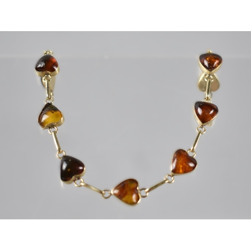 69 - A 14ct Gold and Amber Mounted Line Bracelet Set with Nine Cabochon Heart Shaped Amber Panels, Each 1... 