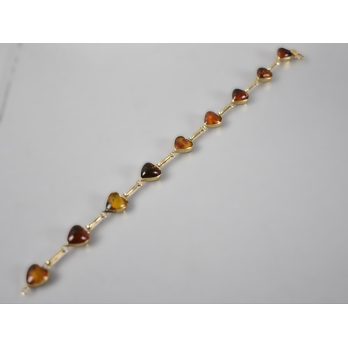 69 - A 14ct Gold and Amber Mounted Line Bracelet Set with Nine Cabochon Heart Shaped Amber Panels, Each 1... 