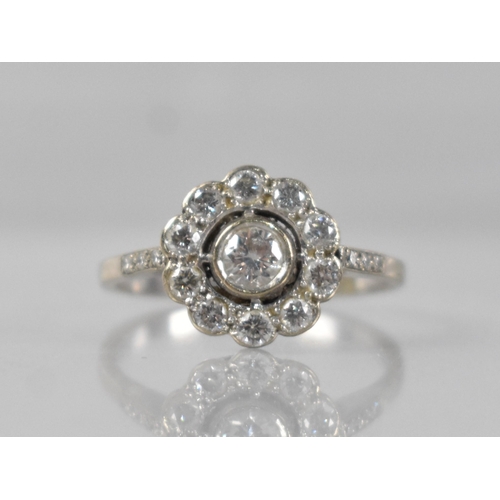 24 - A Diamond Daisy Ring, Central Round Cut Stone 3.9mm Diameter Approx, Bezel Set in White Metal and wi... 