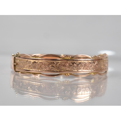 129 - A 9ct Rose Gold Hinged Bangle having Engraved Floral Decoration to Front and Pierced Decoration to E... 