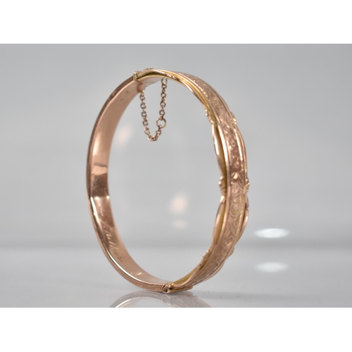 129 - A 9ct Rose Gold Hinged Bangle having Engraved Floral Decoration to Front and Pierced Decoration to E... 