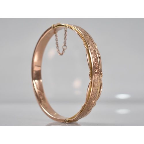 129 - A 9ct Rose Gold Hinged Bangle having Engraved Floral Decoration to Front and Pierced Decoration to E... 