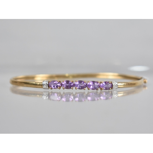 135 - A 9ct Gold Gem Set Bangle, Five Oval Cut Amethysts, Each Measuring 6.3mm by 4.2mm Set in Four Claws ... 