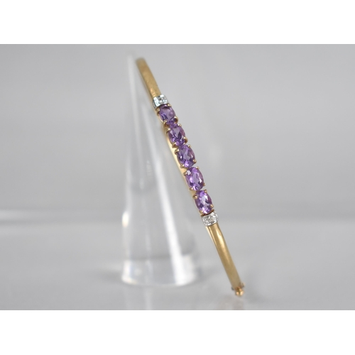 135 - A 9ct Gold Gem Set Bangle, Five Oval Cut Amethysts, Each Measuring 6.3mm by 4.2mm Set in Four Claws ... 