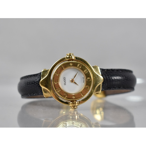 16 - A Vintage Ladies Gucci Wristwatch, White Enamel Dial Inscribed Gucci, Swiss Made and having Gold Col... 