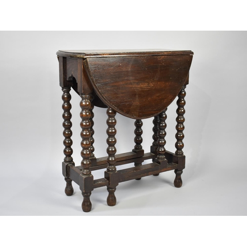 85 - A Small Oak Drop Leaf Gate Legged Table with Bobbin Supports, 63cm Long