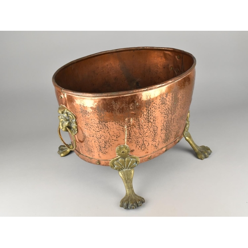 114 - A Brass Mounted Copper Oval Log Basket on Four Claw Feet, Lion Mask Ring Handles, 42cms Wide and 30c... 