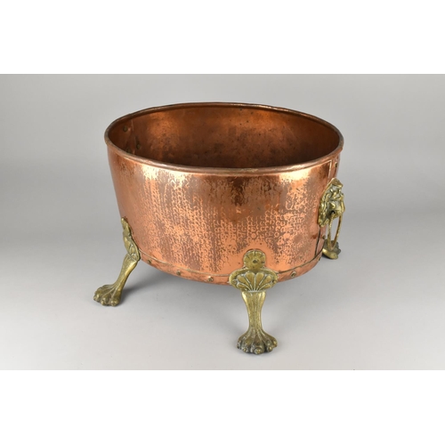 114 - A Brass Mounted Copper Oval Log Basket on Four Claw Feet, Lion Mask Ring Handles, 42cms Wide and 30c... 