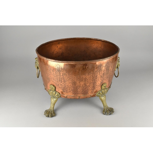 114 - A Brass Mounted Copper Oval Log Basket on Four Claw Feet, Lion Mask Ring Handles, 42cms Wide and 30c... 