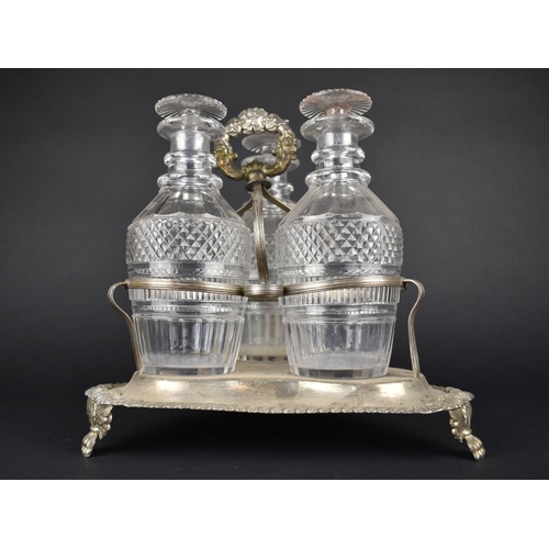 58 - A Georgian Style Three Bottle Tantalus on Silver Plated Stand, Glass Bottles of Mallet Form having C... 