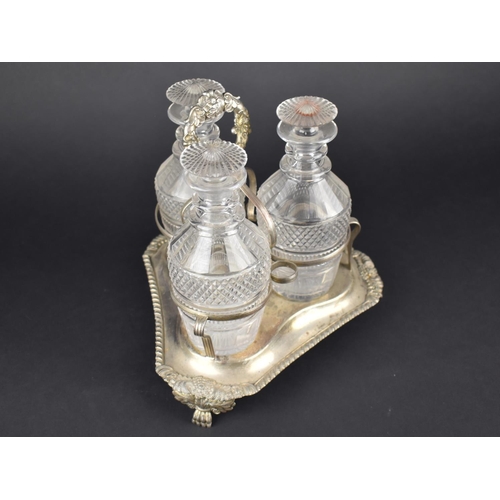 58 - A Georgian Style Three Bottle Tantalus on Silver Plated Stand, Glass Bottles of Mallet Form having C... 