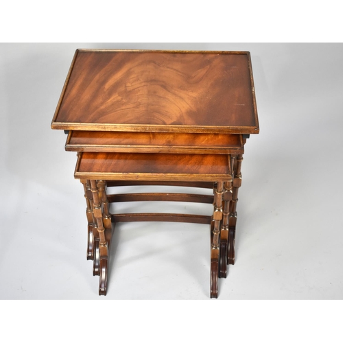 75 - A Reproduction Walnut Nest of Three Tables with Spindle Supports, 50cms Wide