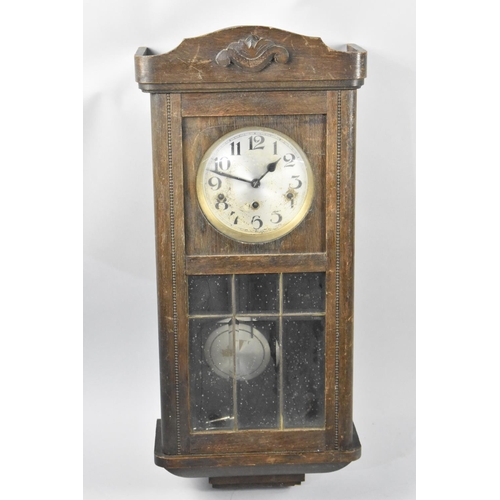 490 - An Edwardian Oak Cased Wall Clock, with Key and Pendulum