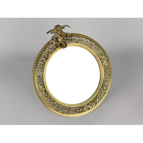 115 - A Nice Quality Circular Pierced Brass Framed Easel Mirror with Cherub Finial, 25cms Diameter