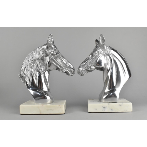 123 - A Pair of Modern Chomed Bookends in the Form of Horse Heads Set on Faux Marble Rectangular Plinths, ... 