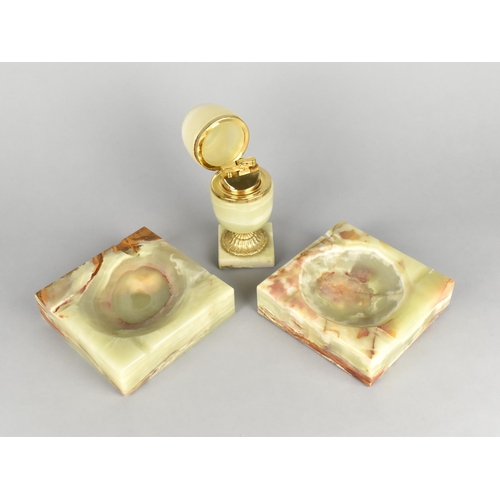 49 - A Brass and Onyx Ovoid Table Lighter with Hinged Lid together with Two Matching Square Ashtrays