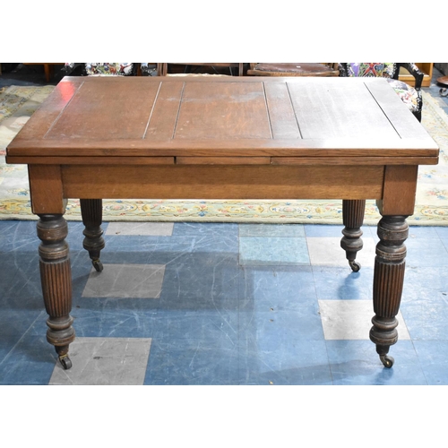 545 - An Edwardian Oak Drawer Leaf Dining Table On Turned Reeded Supports Culminating in Casters, Extends ... 