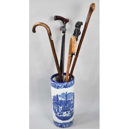 247 - A Cylindrical Blue and White Transfer Printed Ceramic Stick Stand Containing Six Various Walking Sti... 