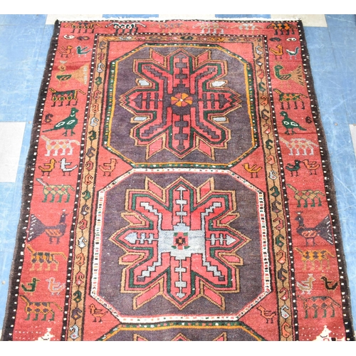 501 - A Patterned Woollen Rug on Red Ground, 230cms by 135cms