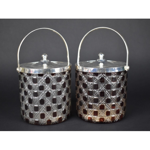 112 - A Pair of Overlaid Ruby Glass Style Biscuit Barrels with Silver Plated Lids and Loop Handles