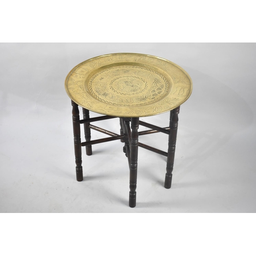 241 - An Indian Benares Brass Tray on Folding Wooden Stand, 66cms Diameter