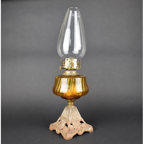 43 - A Late Victorian Iron Based Oil Lamp with Amber Glass Reservoir and Plain Chimney, 50cms HIgh