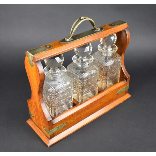 9 - A Mid 20th Century Oak Three Bottle Tantalus, Complete with Key