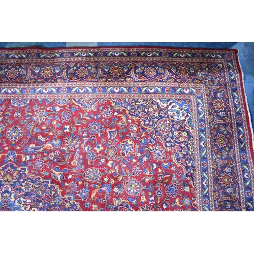 517 - A Large Patterned Rug on Red Ground, 395x286cms