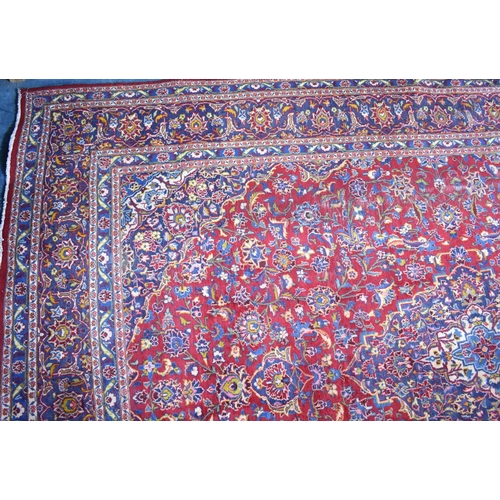 517 - A Large Patterned Rug on Red Ground, 395x286cms