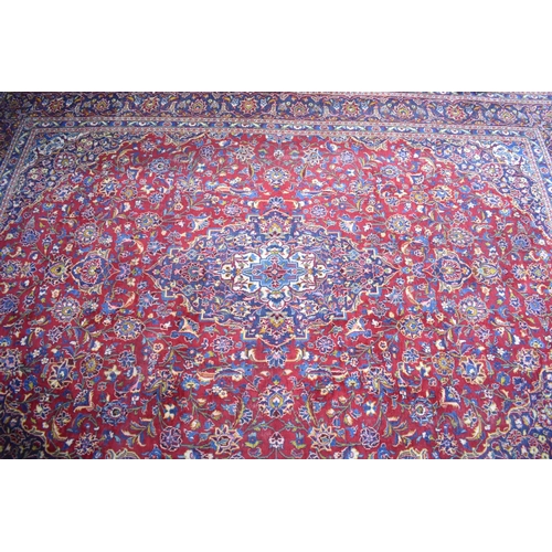 517 - A Large Patterned Rug on Red Ground, 395x286cms