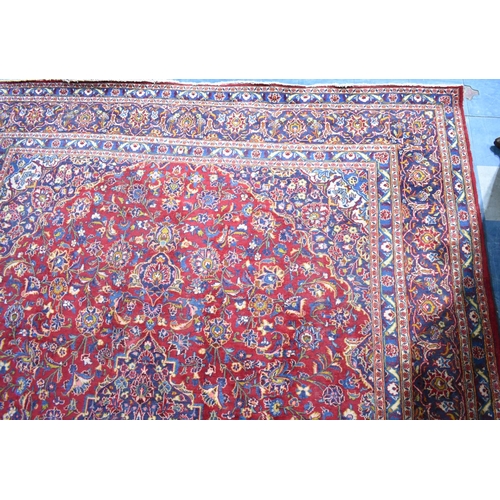 517 - A Large Patterned Rug on Red Ground, 395x286cms