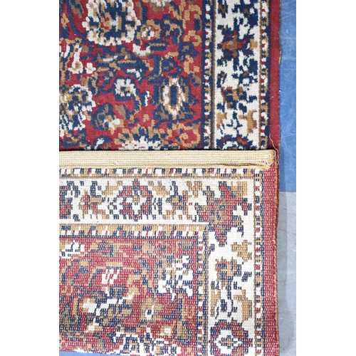 522 - A Patterned Hearth Rug on Red Ground, 148x79cms