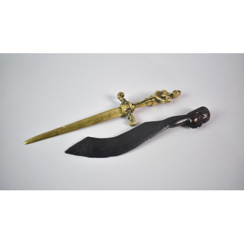 65 - A Carved African Souvenir Letter Opener with Mask Handle and Blade in the Form of Scimitar, together... 