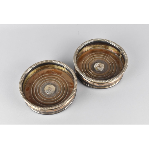 70 - A Pair of Silver Plated Bottle Coasters with Armorial Design to Centre, 