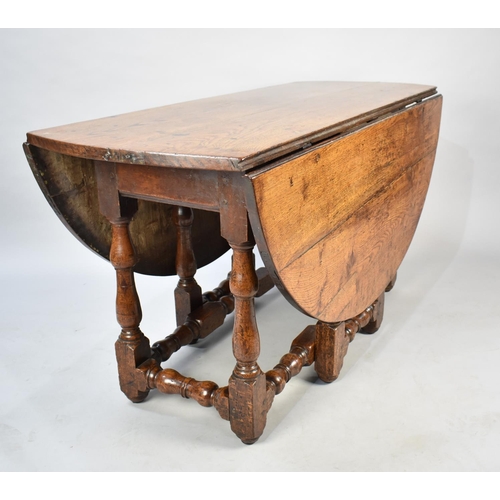 502 - An Early 18th Century Oak Drop Leaf Gate Leg Dining Table with Oval Top, 135cms Long