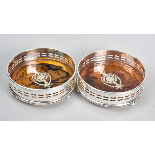 128 - A Pair of Silver Plated and Faux Tortoiseshell Circular Wine Bottle Coasters, Each with Three Ball F... 