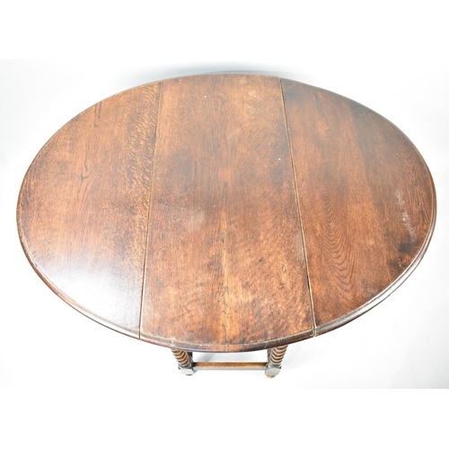 503 - A Mid 20th Century Oak Drop Leaf Gate Leg Barley Twist Oval Topped Dining Table, 102cms Wide