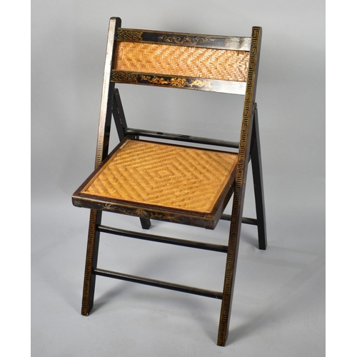 79 - A Lacquered Chinoiserie Folding Chair with Cane Seat and Back