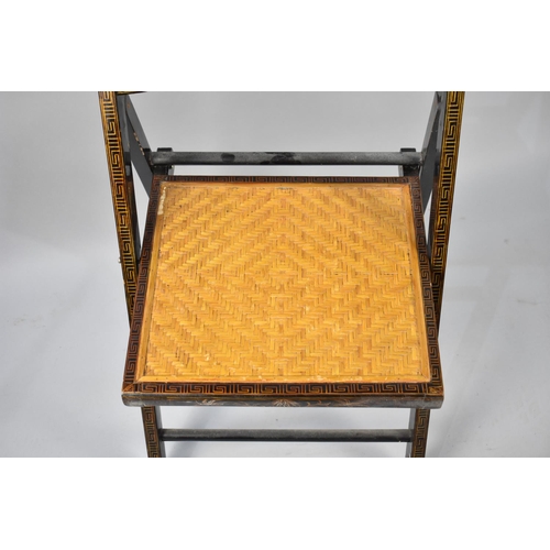 79 - A Lacquered Chinoiserie Folding Chair with Cane Seat and Back