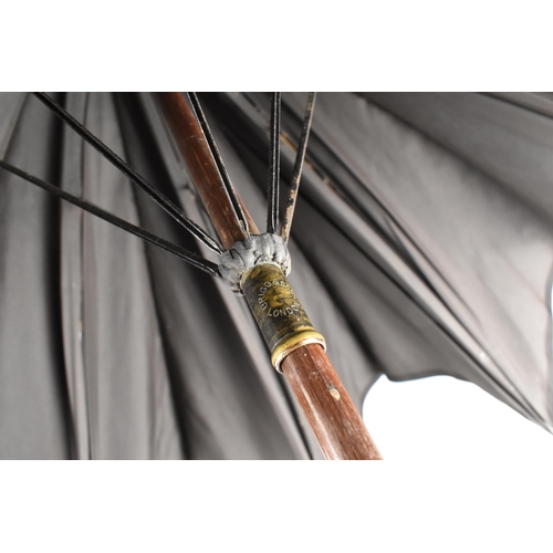 29 - An Early 20th Century Briggs & Sons Parasol with Faux Bamboo Handle Having Large Raw Amber Mounted T... 