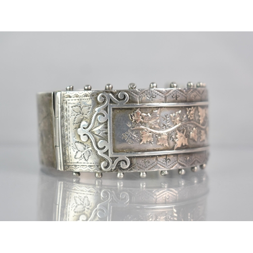 264 - A Victorian Silver Aesthetic Hinged Bangle, Central Rectangular Cartouche with Gilt Metal Ivy/Maple ... 