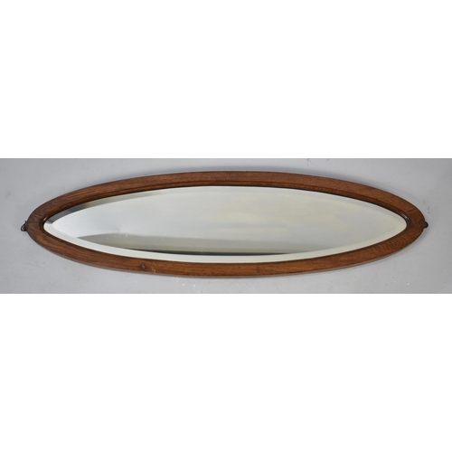 519 - An Edwardian Oak Framed Narrow Oval Wall Mirror, 101cms High by 28cms Wide