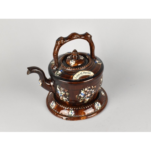 67 - A Treacle Glazed Measham Teapot and Stand, 