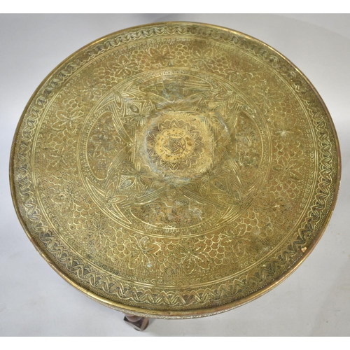 74 - An Indian Brass Benaries Tray on Folding Wooden Stand, 60cms Diameter