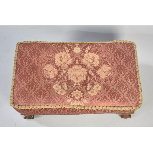 85 - A Rectangular Upholstered Footstool with Claw and Ball Feet, 58cms by 34cms